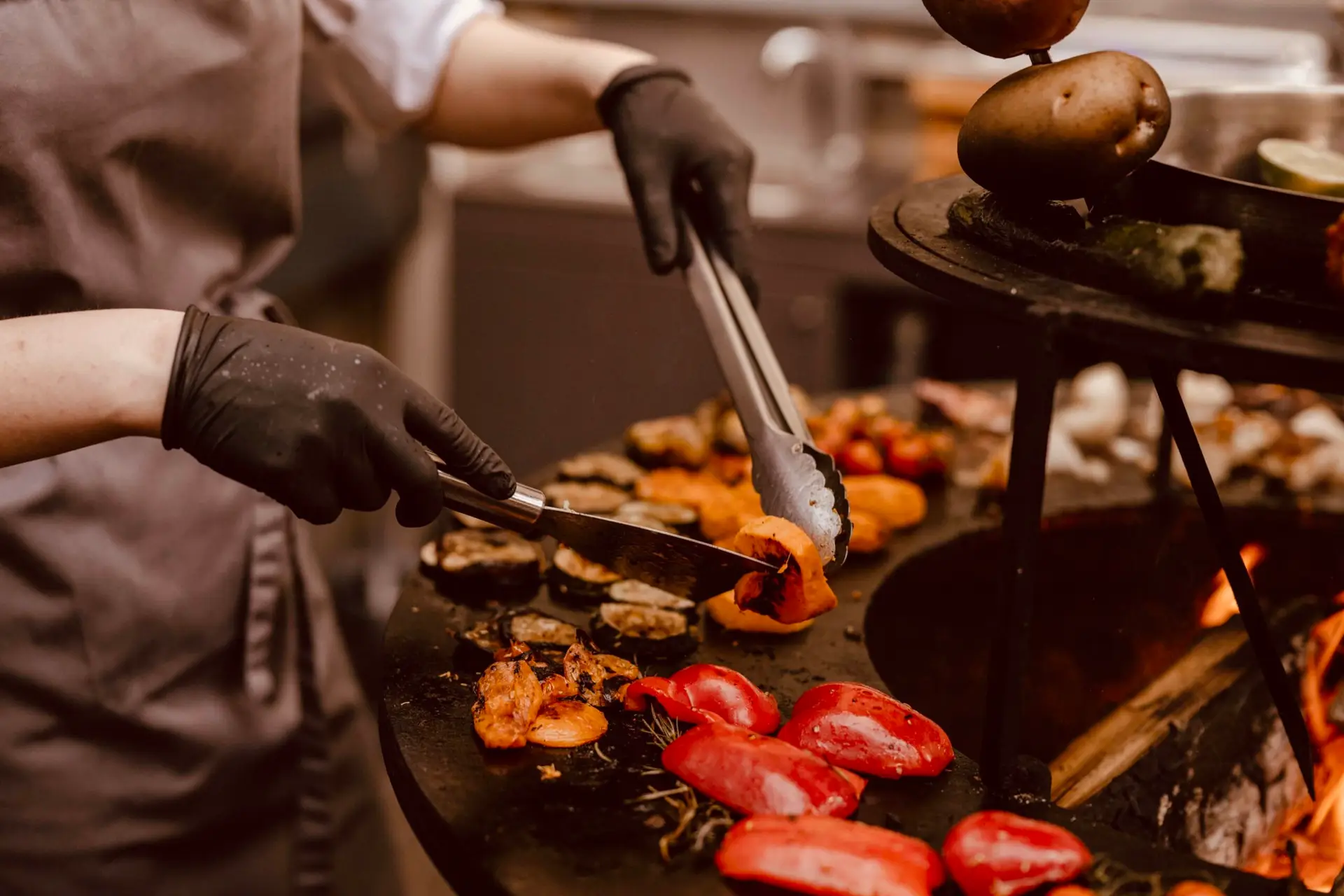 Cuisson de légumes au feu de bois sur un brasero pendant un événement convivial à Bordeaux